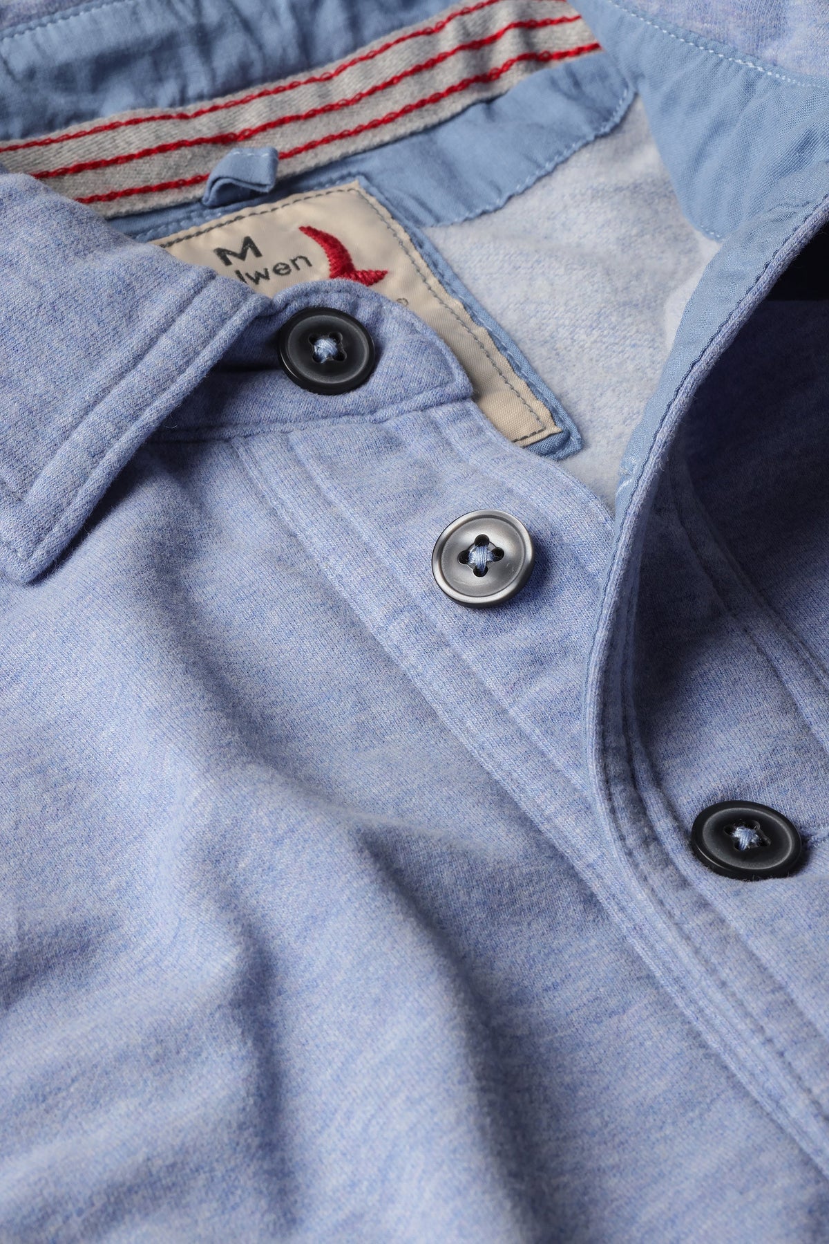 The RELWEN - MARINER POLO IN LIGHT BLUE is a relaxed fit, long-sleeve polo featuring a collar, four-button placket, and front chest pocket. Inspired by the classic French terry polo, this comfortable shirt is displayed laid flat on a white background.