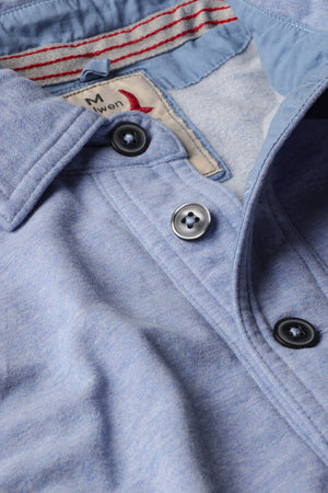The RELWEN - MARINER POLO IN LIGHT BLUE is a relaxed fit, long-sleeve polo featuring a collar, four-button placket, and front chest pocket. Inspired by the classic French terry polo, this comfortable shirt is displayed laid flat on a white background.