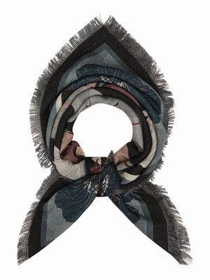 The FRANCO FERRARI - GRIDO REVERSIBLE WOOL SCARF 68X68 features a square shape, with blue, white, and mauve floral patterns on black, fringed edges, and detailed flowers and leaves at the corners and borders.