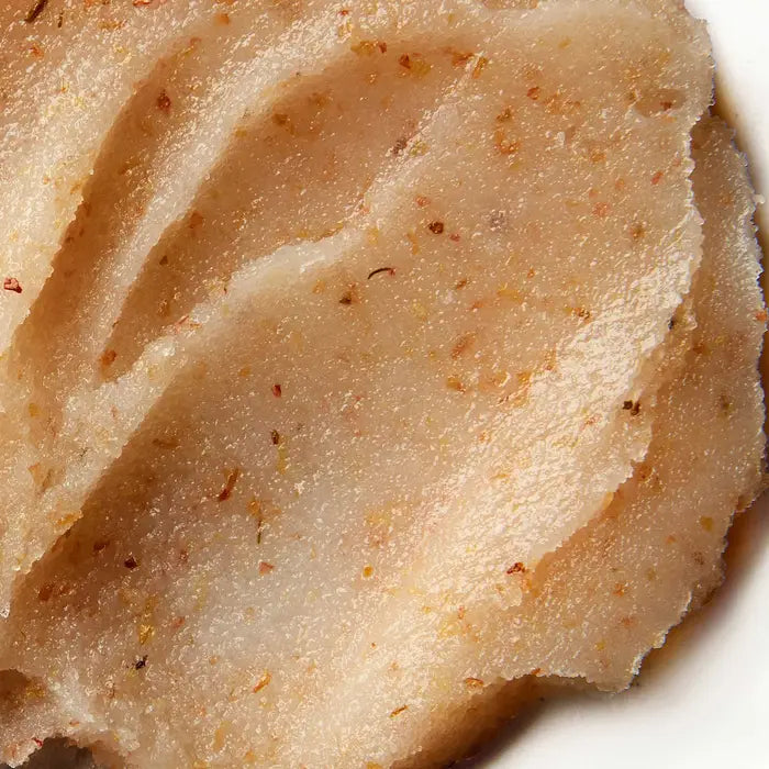 Close-up of a textured, beige-colored food with visible specks, resembling a smooth, mashed or pounded substance, possibly a traditional starchy dish on a white background.