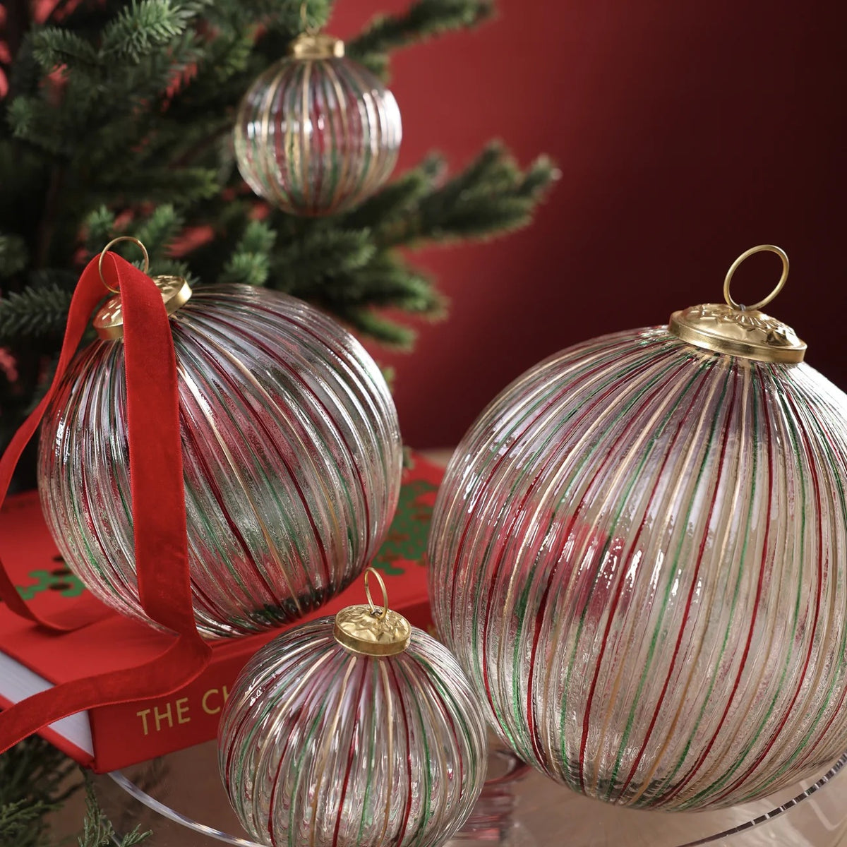 RIBBED MULTI RED AND GREEN GLASS ORNAMENT: a 4-inch ribbed glass ball featuring vertical red, green, and gold stripes with a gold cap.