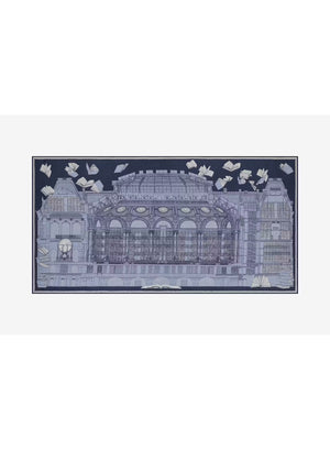 A woman stands against a plain background, wearing a beige sweater, cream wide-leg pants, black shoes, and the INOUI EDITIONS - VIVIENNE WOOL SCARF IN BLUE by INOUI—a long blue scarf with a white pattern made from 100% wool in India and measuring 100 x 190 cm.