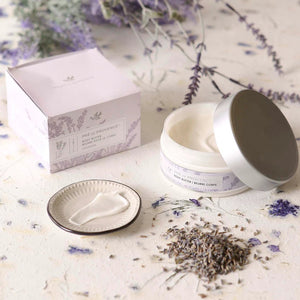 A 200 ml (6.7 fl oz) jar of BODY BUTTER - LAVENDER by EUROPEAN SOAPS, LLC, enriched with shea butter for deep moisturization. The round container features a silver lid and a white label adorned with light lavender illustrations and details about the product in both English and French.