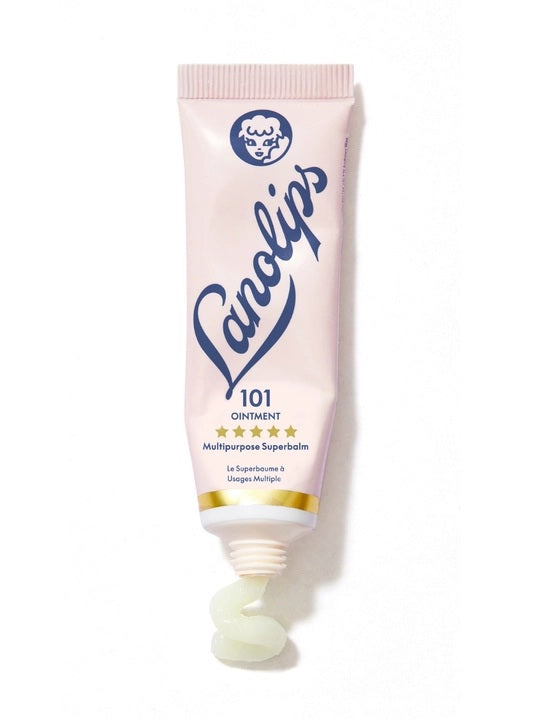 A pink tube labeled “LANOLIPS - 101 OINTMENT MULTIPURPOSE SUPERBALM” from LANOLIPS—an ultra-hydrating moisturizer—displays a blue logo with a sheep’s head and five gold stars, standing upright on a white background.