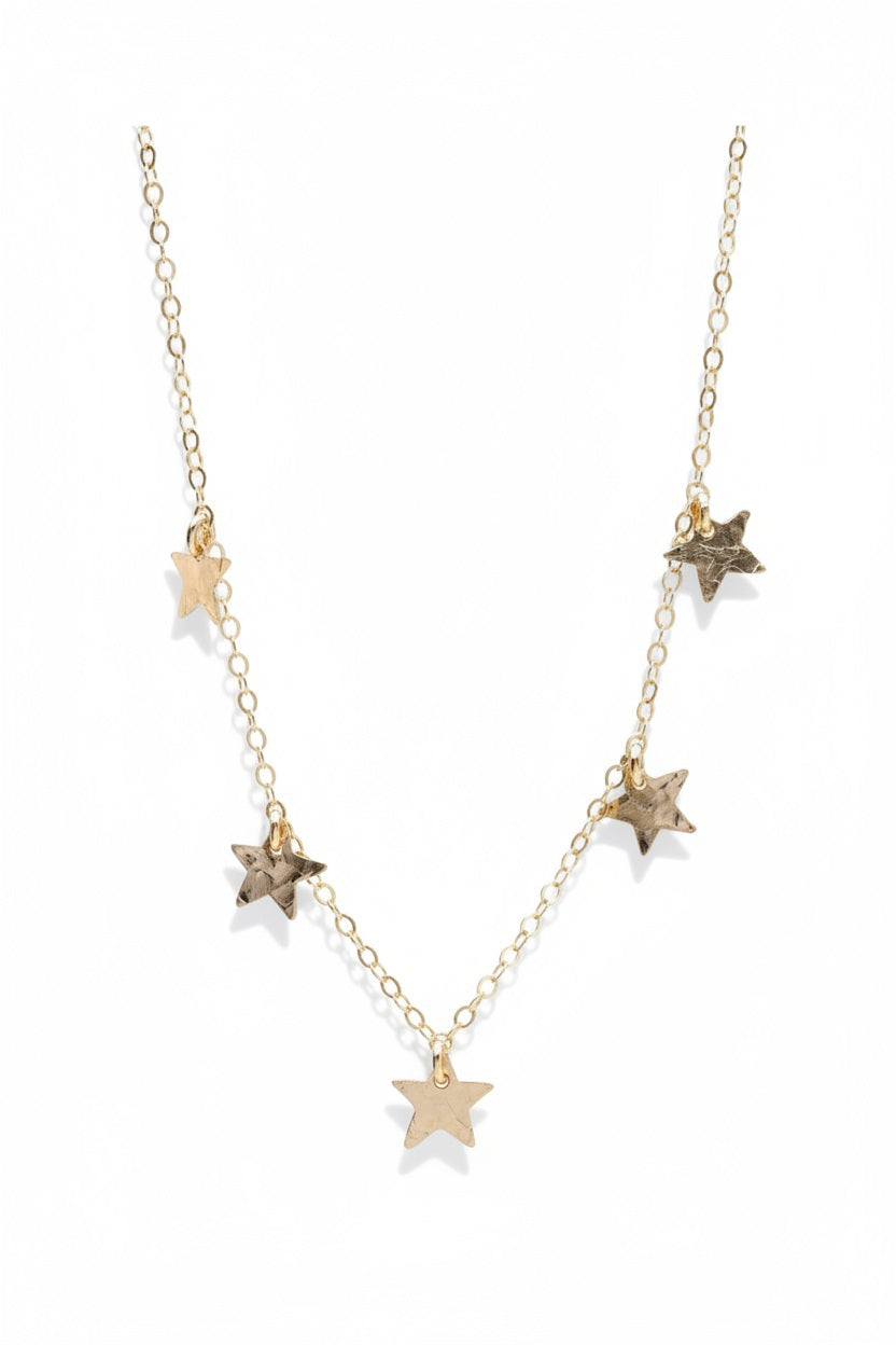 The KENDA KIST - THE 5 STAR CHOCKER NECKLACE is a delicate 14k gold filled choker featuring dainty stars along an elegant chain, designed by KENDA KIST.