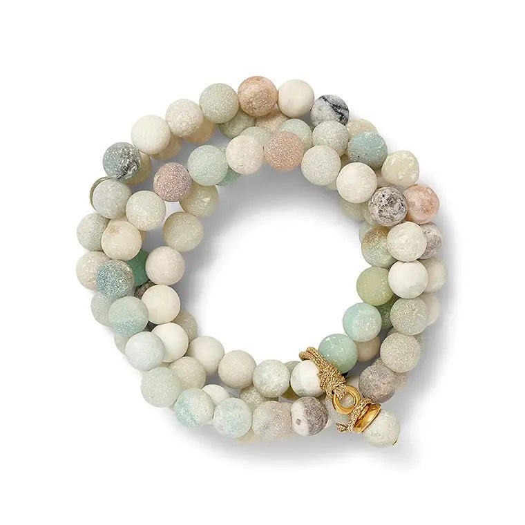 The CC &amp; CO by Catherine Canino Sally Bracelet in Druzy Quartz is a stretchy bracelet made with round, semi-precious beads in white, beige, green, and gray shades. It features a hint of blue druzy quartz and a gold clasp for an elegant touch.
