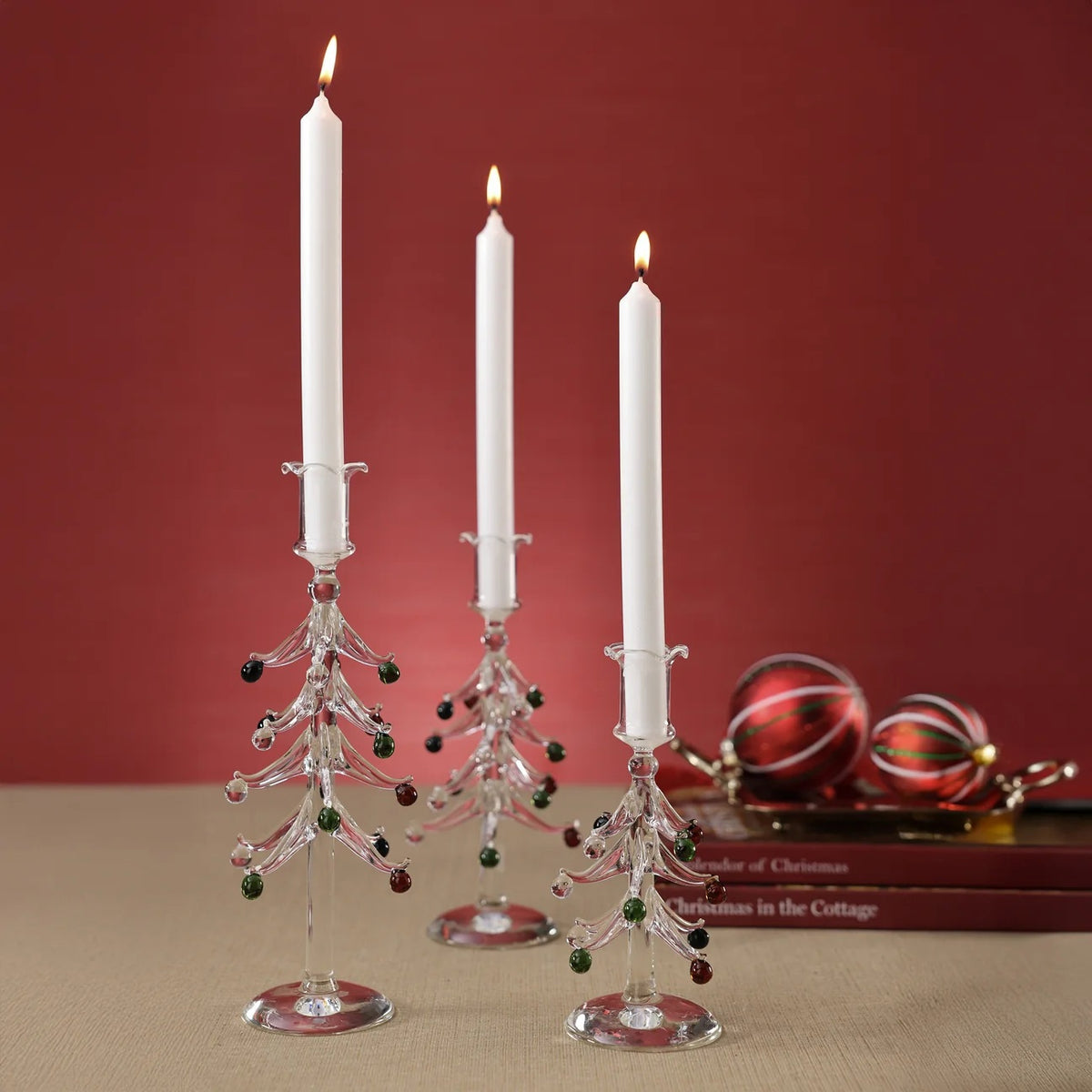 ZODAX HOLIDAY TREE GLASS TAPER CANDLE HOLDER 8.25″ made of clear borosilicate glass in the shape of a Christmas tree with small red and green glass ornaments.