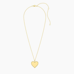 The ELLA STEIN - FOREVER LOVE PENDANT NECKLACE by ELLA STEIN features a gold-plated, heart-shaped pendant outlined with shimmering natural diamonds, suspended from a delicate gold chain and showcased against a plain white background.