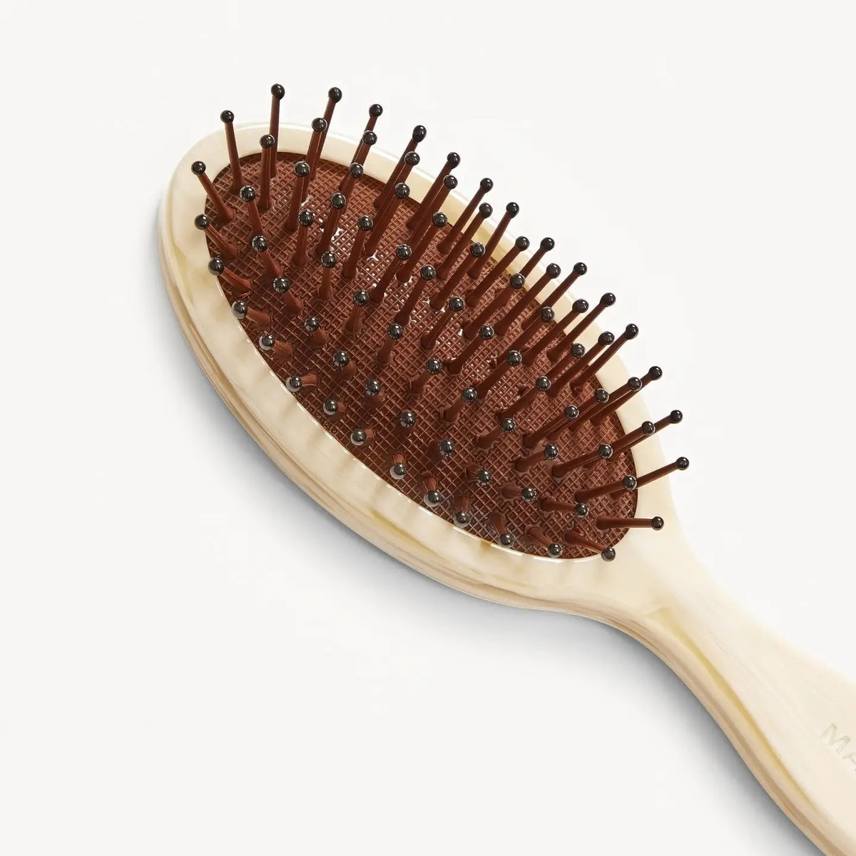 The MACHETE - Petite Travel Detangling Hair Brush in Alabaster features an oval head, brown cushioned base, and nylon bristles. The wooden handle is engraved with "MACHETE" and is shown against a plain white background.