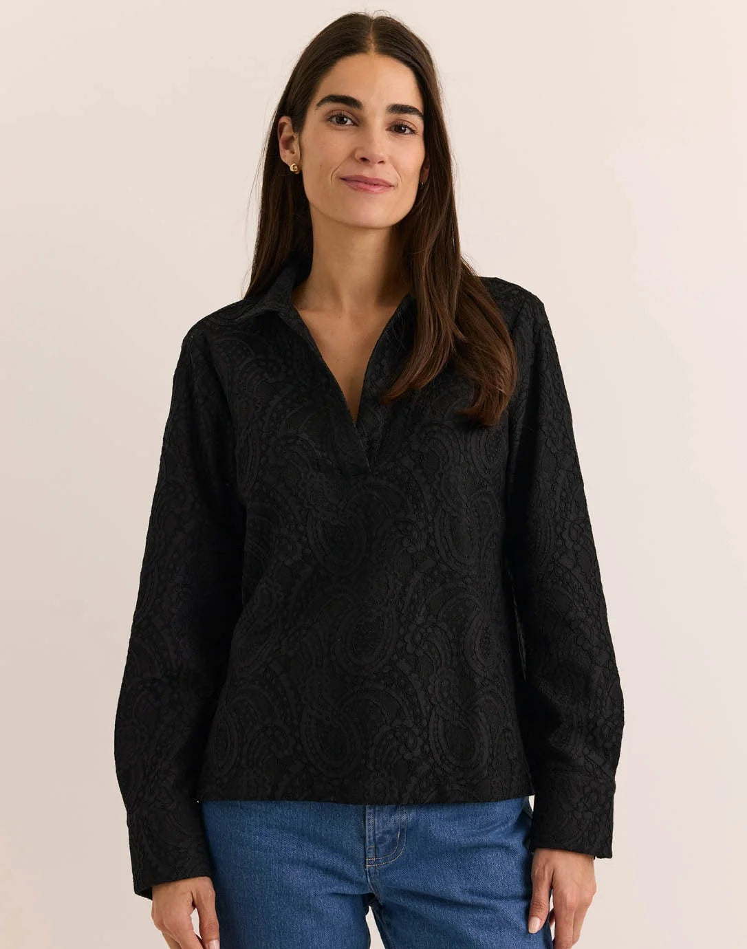A woman wearing a HINSON WU - MONA LONG SLEEVE BONDED LACE SHIRT in black, paired with black trousers, black heels, and a black clutch.
