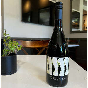 A bottle of CHIARA PINOT NOIR 2021 with a label featuring a repeating silhouette illustration of a person and the text “CHIARA PINOT NOIR.”