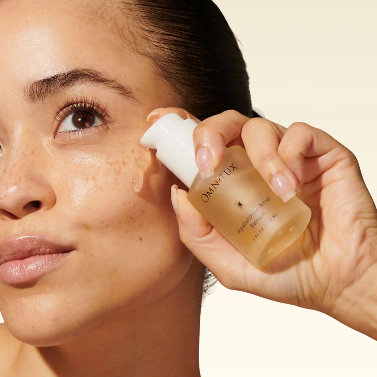 A skincare graphic featuring the OMNILUX - HYALURONIC ACID SERUM, 30ML by OMNILUX spotlights hyaluronic acid for deep hydration, niacinamide to refine skin texture, and licorice root for soothing benefits. The clear gel serum is highlighted with bubbles in the background—ideal for pairing your hyaluronic acid routine with advanced treatments like LED light therapy to achieve radiant results.