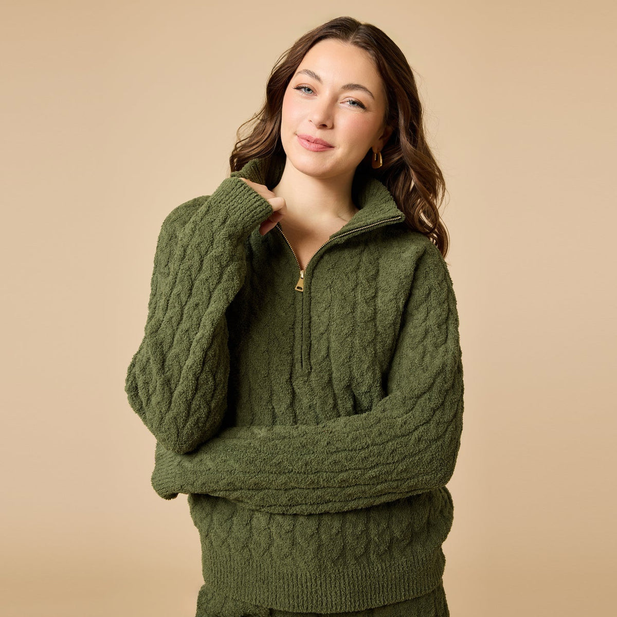 A woman wearing a marshmallow-soft, cream-colored SOFTIES - CABLE KNIT MARSHMALLOW ½ ZIP WITH TAPERED PANT SET, featuring a half-zip pullover and matching pants with a drawstring waist.