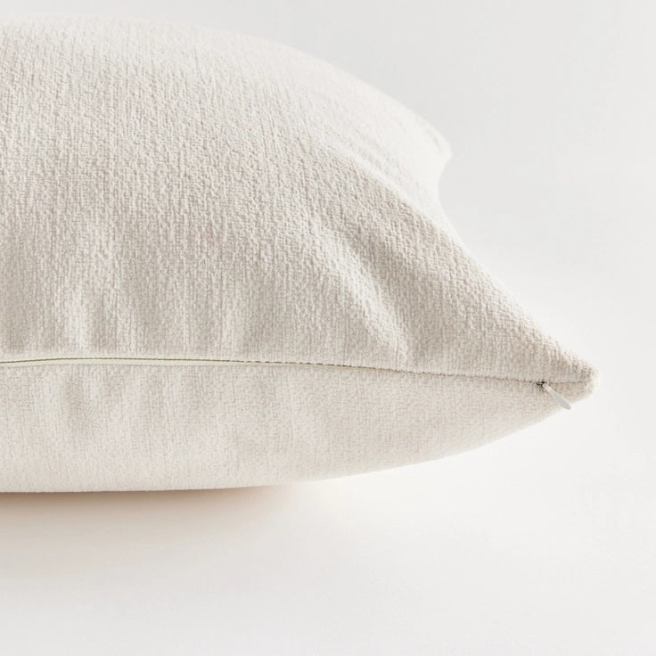 Against a plain white background, the NAPA HOME AND GARDEN - COOPER SQUARE INDOOR-OUTDOOR PILLOW 20&quot;, with its soft and fluffy Jacquard texture, appears smooth and slightly plump, ideal for resting or sleeping in any weather-resistant setting.