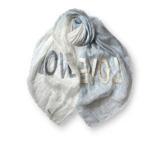 Discover the CITRUS FASHIONS OMBRE LINEN LOVE SCARF, an elegant blend of colors and emotions with one half in vibrant orange and the other in pure white. This dip-dyed treasure spells "LOVE" in contrasting letters, adding warmth and charm to any outfit.