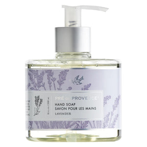 A clear pump bottle labeled "EUROPEAN SOAPS, LLC" contains lavender-scented HERITAGE LIQUID SOAP enriched with glycerin. The label features lavender plant illustrations and text in both English and French. The light purple liquid soap inside adds to the packaging's elegant and minimalistic appeal.