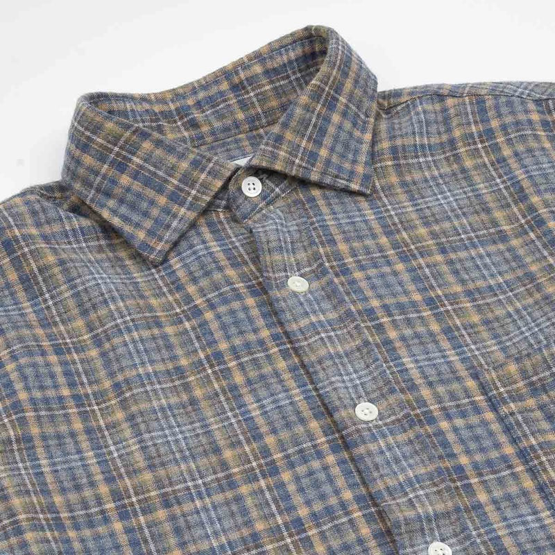 A close-up of the HARTFORD - PAUL Checked Flannel Shirt in Grey highlights the blue, brown, and grey plaid cotton fabric, with a focus on the cuff and sleeve featuring visible white buttons.