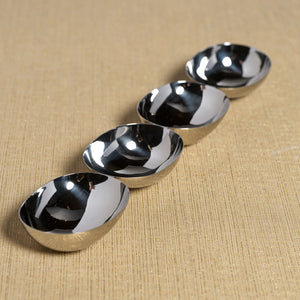 Four 15-inch silver-colored metal bowls arranged in a diagonal line, known as the ZODAX FOUR TIER NUT BOWL IN POLISHED NICKEL.