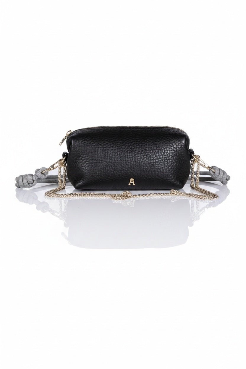 The CRAIE STUDIO - NUAGE BUBBLE NOIR MINI BAG is a chic black textured lambskin crossbody from CRAIE STUDIO, designed with signature bubble leather for subtle dimension. Featuring elegant gold chain strap and hardware, plus distinctive gray knotted accents on each side, this stylish mini bag is displayed against a crisp white background.