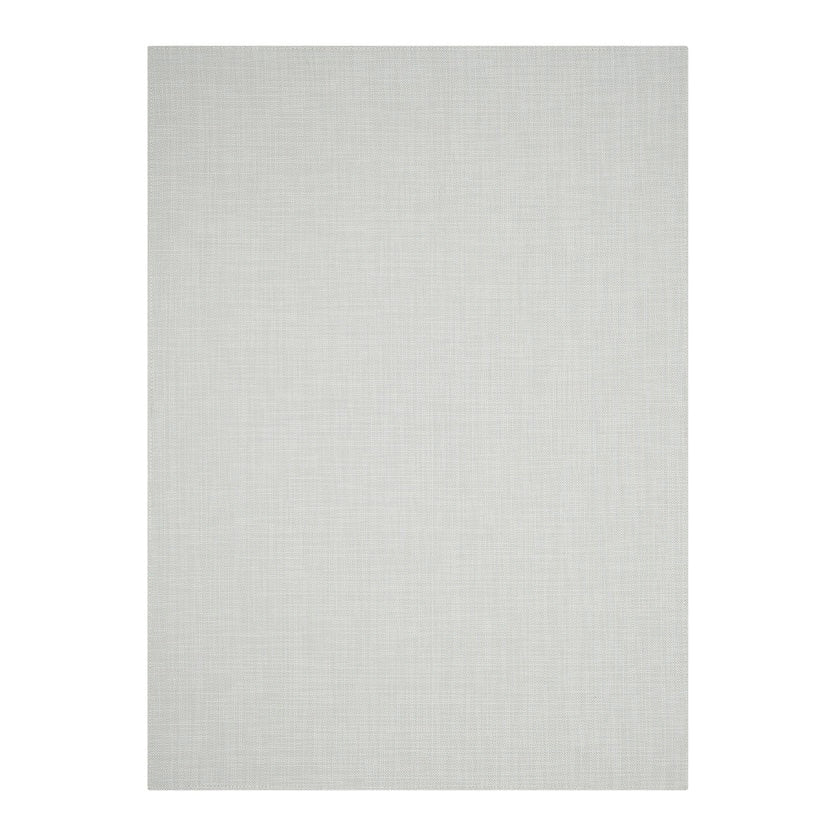 A simple wooden chair with a curved backrest and white metal legs sits on the CHILEWICH MINI BASKETWEAVE RUNNER 2.5X8, made from phthalate-free TerraStrand yarns, against a white wood-paneled wall.