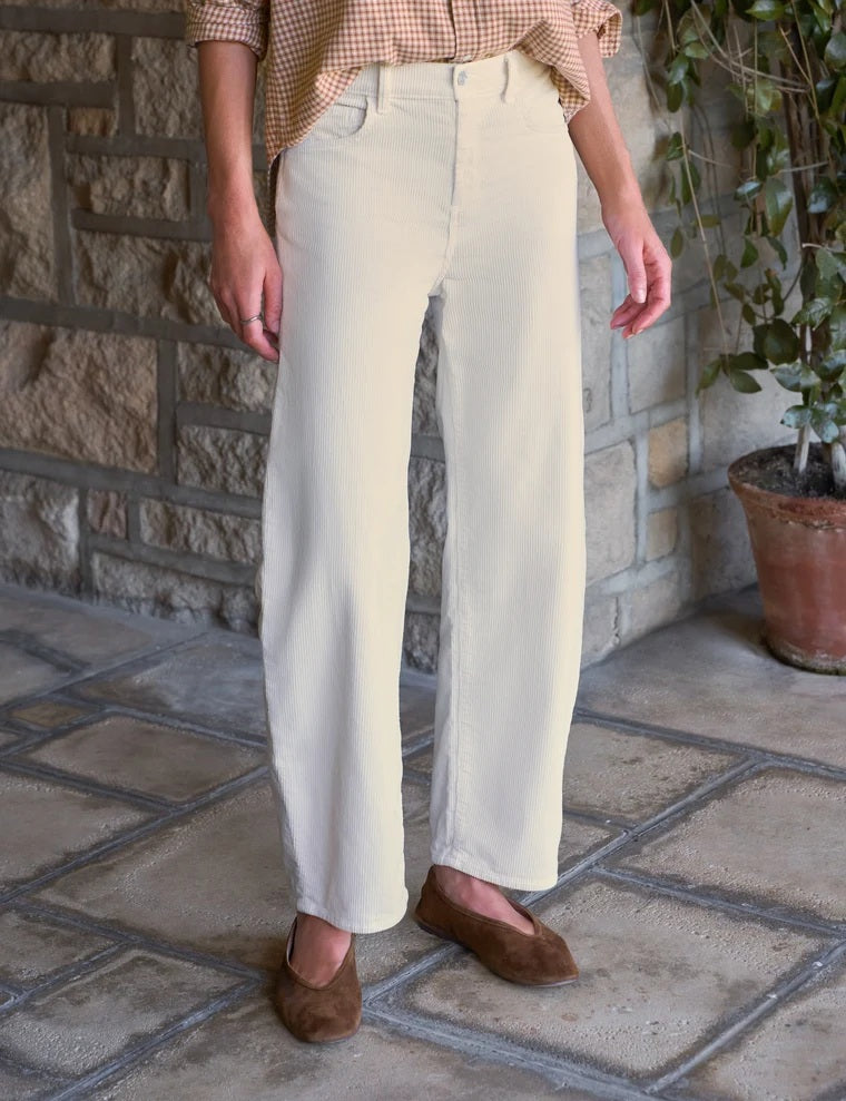 A woman wearing a tan and white gingham button-down shirt tucked into FRANK AND EILEEN - BRENNAN EVERYDAY BARREL IN ITALIAN PERFORMANCE CORDUROY VINTAGE WHITE barrel jeans.