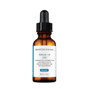 A brown dropper bottle labeled "SKINCEUTICALS - SERUM 10 AOX" stands against a white background. The label mentions it combines 10% L-ascorbic acid with ferulic acid to provide antioxidant and anti-aging benefits for sensitive skin, and the bottle contains 30 ml (1 fl oz) of product.