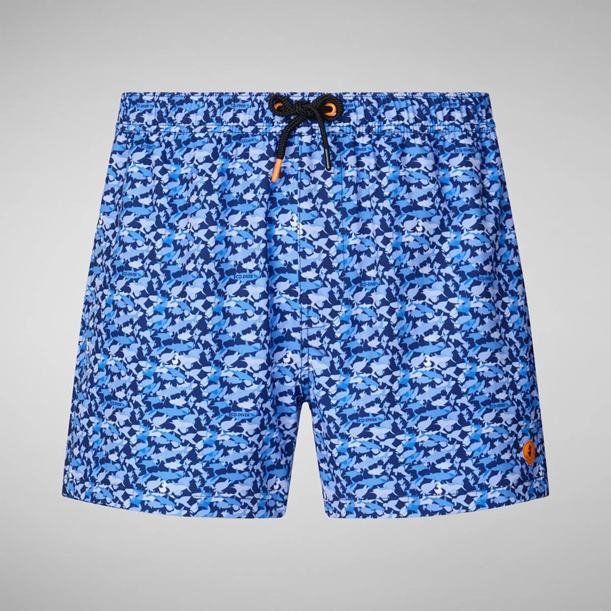 SAVE THE DUCK - ADEMIR SWIM TRUNKS IN BLUE SHARK: Quick-dry recycled polyester men's swim trunks featuring a blue and navy shark print, drawstring waistband, orange logo patch on the lower left leg, and plain light gray background.