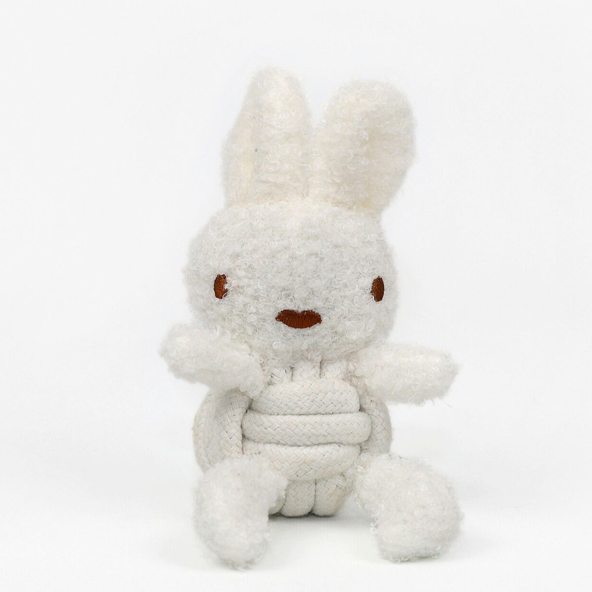 The KNOTTY PAWS - SQUEAKY ROPE BUDDIES by KNOTTY PAWZ is a charming, eco-friendly dog toy. It's a beige, textured plush rabbit with brown stitched eyes and a smiling mouth, seated against a white background. Perfect for delighting your furry friend sustainably.