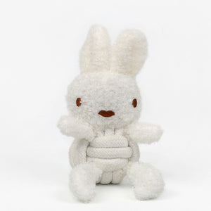 The KNOTTY PAWS - SQUEAKY ROPE BUDDIES by KNOTTY PAWZ is a charming, eco-friendly dog toy. It's a beige, textured plush rabbit with brown stitched eyes and a smiling mouth, seated against a white background. Perfect for delighting your furry friend sustainably.