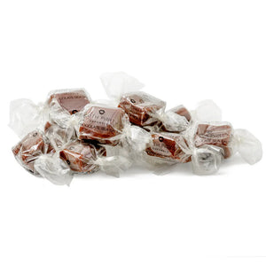 A clear bag of MOUTH PARTY - CHOCOLATE SEA SALT caramels from MOUTH PARTY, tied with a shiny brown ribbon. The label features a pink lips logo and product details.