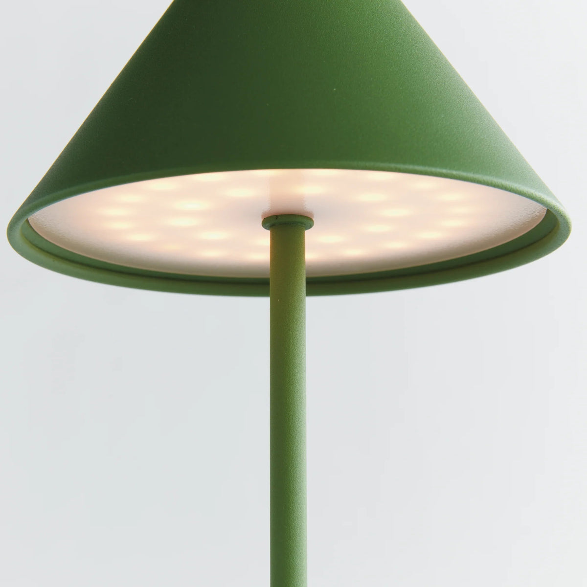 The NAPA HOME AND GARDEN - ALLUNA 10” Cordless LED Lamp in green, a compact and modern luxury table lamp featuring a metal conical shade and a round base, is displayed against a plain white background.