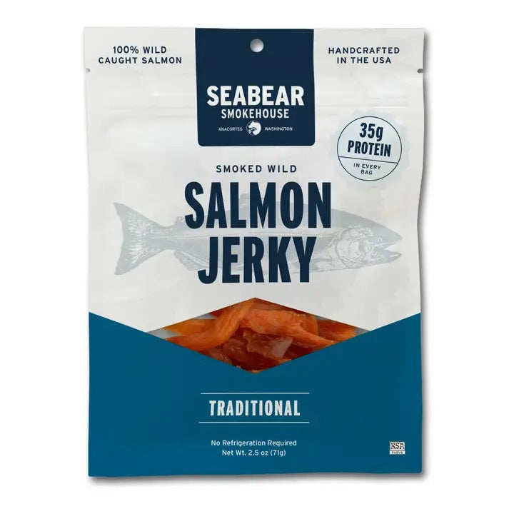 A package of SEABEAR SMOKEHOUSE Searbear Smokehouse Traditional Smoked King Salmon Jerky, featuring tasty pieces of smoked king salmon jerky inside. The packaging highlights 35g of protein per bag and notes that it’s handcrafted in the USA from wild-caught king salmon, making it a high-protein snack you can enjoy anytime.