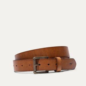 The WILL LEATHER GOODS - SADDLE BELT is a brown full-grain leather belt with a metal buckle and an embossed animal logo near the end, coiled on a plain white background—a timeless classic from WILL LEATHER GOODS for jeans.