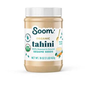 A jar of SOOM - ORGANIC TAHINI from SOOM FOODS, crafted entirely from silky-smooth, roasted and ground Ethiopian sesame seeds. The label proudly displays the USDA Organic certification and indicates a net weight of 16 ounces (453 grams). Additionally, it features an illustration of a spoon alongside ingredients such as carrots and cucumbers.