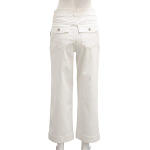 A woman stands confidently with her arms crossed, modeling a long-sleeve white top paired with high-waisted, wide-leg brown SPANX - STRETCH TWILL CROPPED PANTS. She completes the look with white slip-on shoes and is posed against a plain white background, gazing directly at the camera.