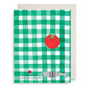 E. FRANCES PAPER’s Tomato Picnic Love & Friendship Card features a green and white checkered design, a red tomato, and gold “Warm sun, sweet days, only thing missing is you.” text. Made in the USA. Envelope included.