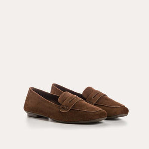 The REQINS HEMA suede loafer in cacao features moccasin-style stitching, a penny strap, and a low black heel for stylish comfort, showcased on a light background.