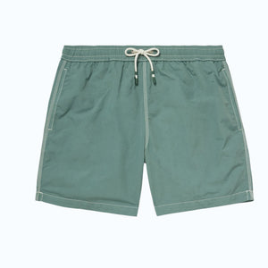 A pair of HARTFORD nylon swim trunks in Faded Kelly with white stitching and side pockets, shown flat on a light background. Includes travel pouch.
