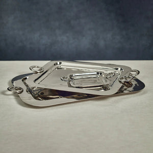 The ZODAX POLISHED BRASS SERVING TRAY is a rectangular metal tray with rounded corners and two circular handles, shown on a white background. Size: 21.25 in x 15.5 in x 1 in.
