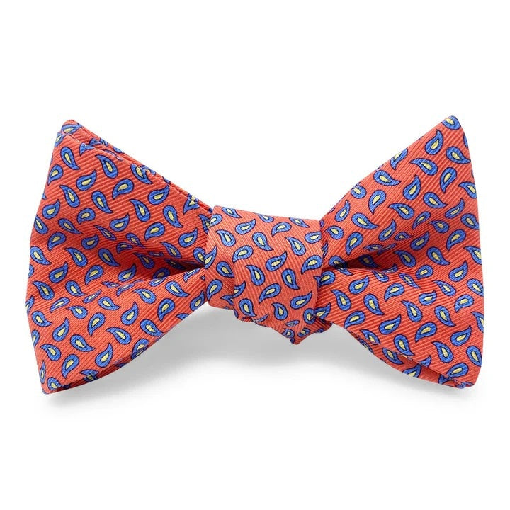 A self-tie, adjustable neck bow tie from Bird Dog Bay, the PETER-BLAIR New Pine Silk Bow Tie in Pink and Blue features a repeating blue and pink pattern, laid flat on a white background. This handmade bow tie is crafted from printed silk for a refined and elegant finish.