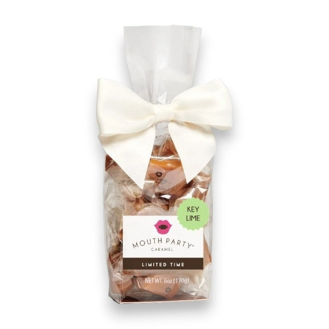 A clear bag of MOUTH PARTY Key Lime Caramels, tied with a white bow and labeled “Key Lime” and “Limited Time,” contains 6 oz (170g) of gluten-free caramels wrapped in clear wrappers. These treats from MOUTH PARTY offer a refreshing summertime flavor.