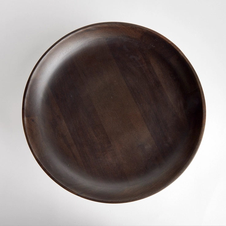 The NAPA HOME AND GARDEN - BOWIE FOOTED BOWL features a dark mango wood pedestal design with a wide, shallow bowl and sturdy base. Its smooth finish showcases natural grain patterns, merging classic craftsmanship with contemporary style against a plain white background.