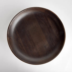 The NAPA HOME AND GARDEN - BOWIE FOOTED BOWL features a dark mango wood pedestal design with a wide, shallow bowl and sturdy base. Its smooth finish showcases natural grain patterns, merging classic craftsmanship with contemporary style against a plain white background.