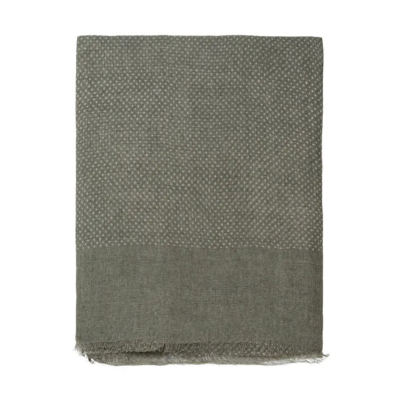 An elegantly folded AMANDA CHRISTENSEN Jacquard Woven Linen Scarf in olive displays a subtle dot pattern across the upper portion and a solid section at the bottom, finished with lightly frayed edges—an exquisite addition to any men’s accessories collection.