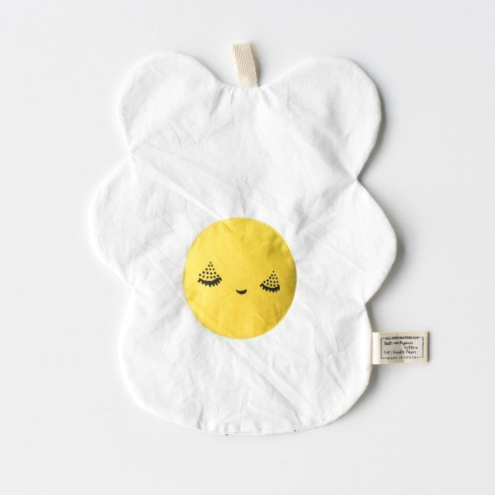 The WEE GALLERY - EGG CRINKLE TOY by WEE GALLERY is a white baby crinkle toy in the shape of a flower with a yellow circle at the center that features a smiling face with closed eyes. Made from organic cotton, it comes with a brown tag inscribed "Baby Crinkle Toy - Organic Crinkle Toy." The toy is displayed hanging on a white hook.