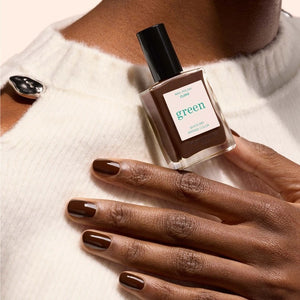 A bottle of MANUCURIST - GREEN™ Nail Polish in Clove by MANUCURIST INC, featuring a rich chocolate brown shade and a black cap. The label reads “green quick dry intense color.”.