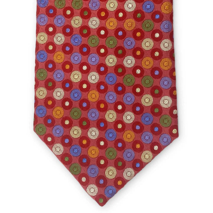 The BIRD DOG BAY PETER-BLAIR Bespoke Circle Field Woven Silk Tie in red showcases colorful polka dots and is handmade in New York. Neatly rolled, it is displayed on a white surface.