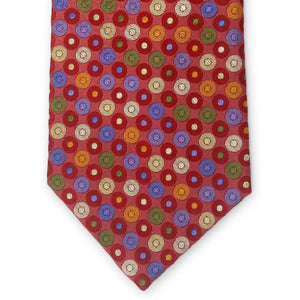 The BIRD DOG BAY PETER-BLAIR Bespoke Circle Field Woven Silk Tie in red showcases colorful polka dots and is handmade in New York. Neatly rolled, it is displayed on a white surface.