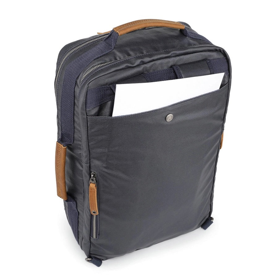 The TSD BRAND - MADRONE COATED CANVAS BACKPACK IN NAVY features brown leather accents, a spacious main compartment, a padded laptop sleeve with snap closure, and multiple zippered pockets on the inside flap.