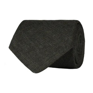 A close-up of the AMANDA CHRISTENSEN Jacquard Linen Tie in dark olive highlights the refined elegance of men’s accessories, featuring a rich textured design and a signature black label reading “Amanda Christensen, Sweden 1885” stitched on the back.